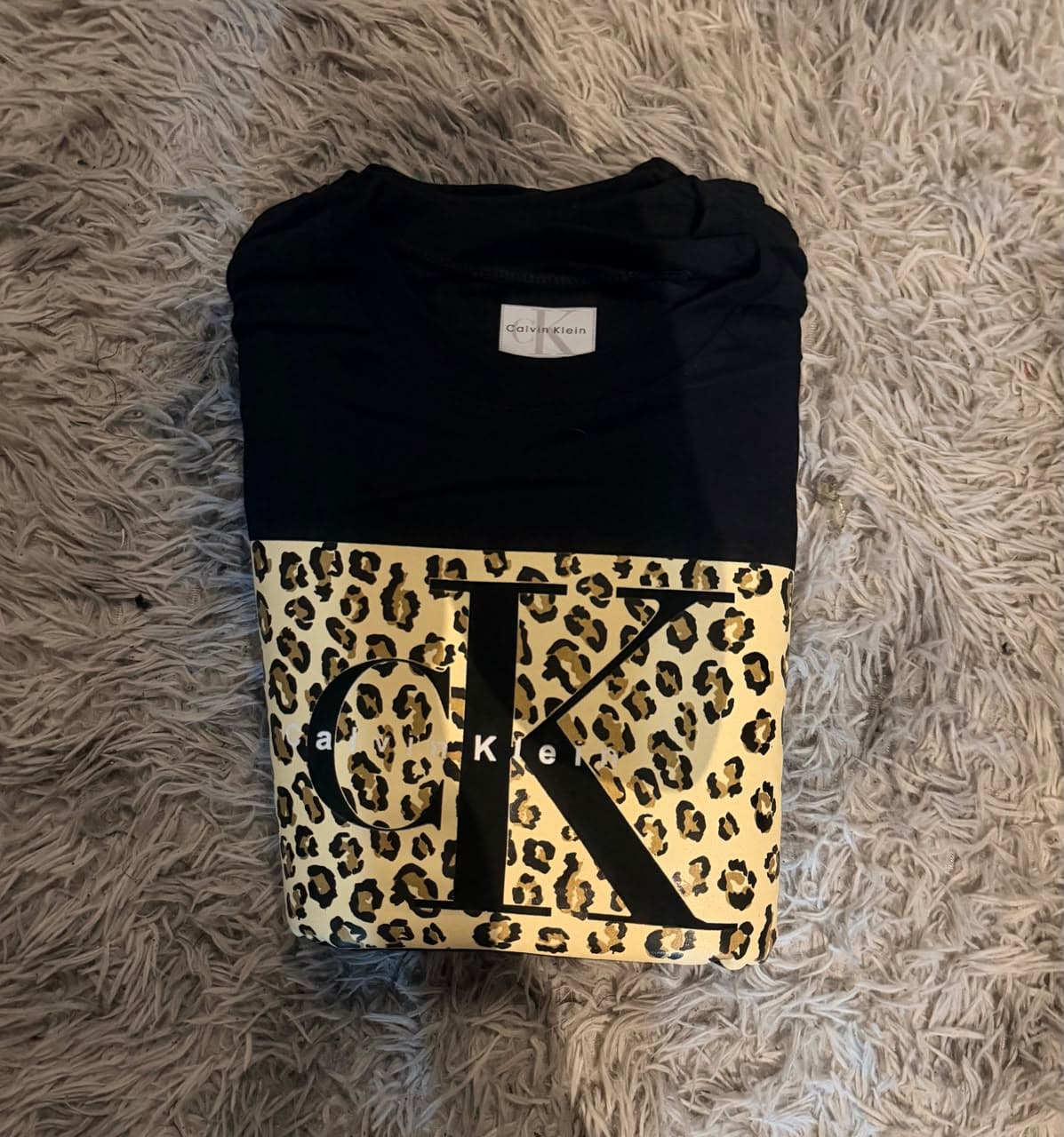 Playera Calvin Klein negra con logo CK y estampado animal print